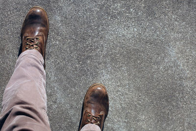 Low section of man wearing shoes standing on floor