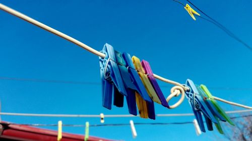 Low angle view of clothes hanging on clothesline against blue sky