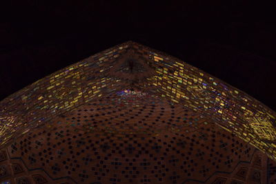 Low angle view of illuminated building against sky at night