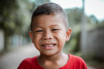 Close-up portrait of smiling boy standing outdoors
