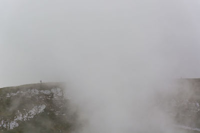 Snow covered land against sky