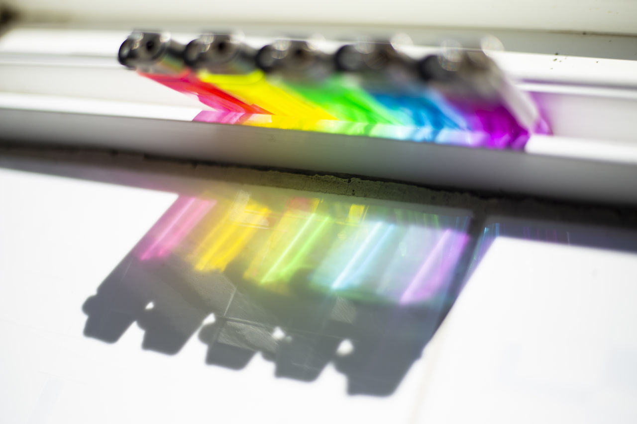 CLOSE-UP OF COLORED PENCILS ON TABLE AGAINST WHITE BACKGROUND