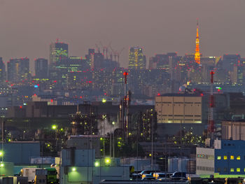 Illuminated buildings in city against sky at night