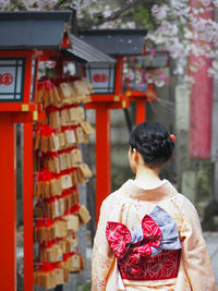 Rear view of woman wearing kimono outside temple