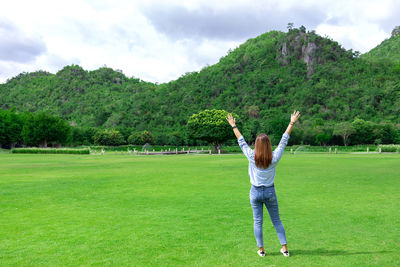 Rear view of person on field against sky