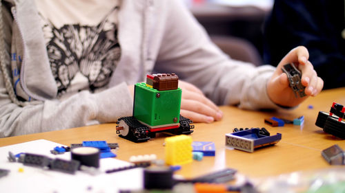 Close-up, children's hands hold a multicolored small robot, machine, 