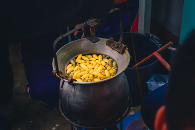 High angle view of people in cooking silk cocoon soup in pan