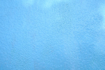 Full frame shot of snowflakes on blue wall