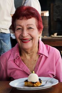 Close-up of smiling mature woman with dessert