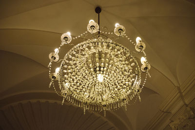 Low angle view of illuminated light bulb hanging from ceiling