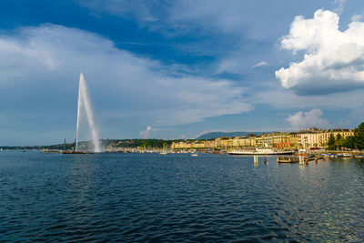 Sailboats in sea against buildings in city