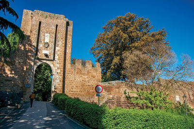 Road by building against clear blue sky