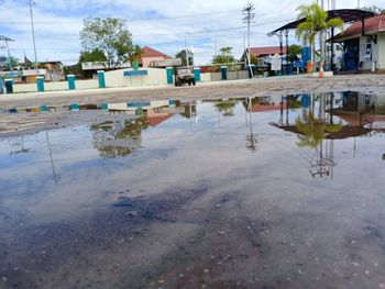 Reflection of building in puddle on street