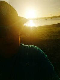 Close-up of man at beach during sunset