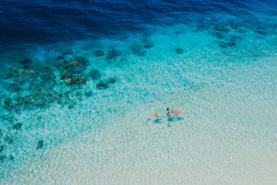 Drone view of man kayaking in sea on sunny day