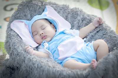 Portrait of cute baby girl lying on bed at home