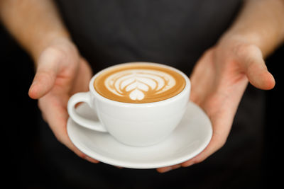 Cropped image of hand holding coffee cup