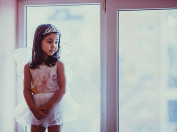 Young woman looking through window