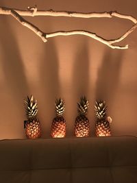 Pineapples on table against wall