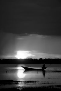Silhouette man in sea against sky