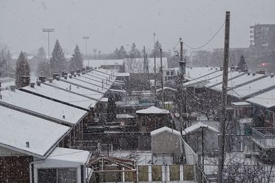 High angle view of snow covered city against sky