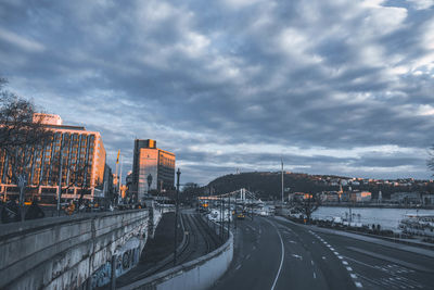 Road by city against sky during winter