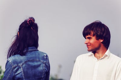 Rear view of couple kissing against sky