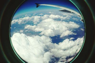 Cropped image of airplane flying over clouds