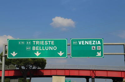 Low angle view of road sign against blue sky