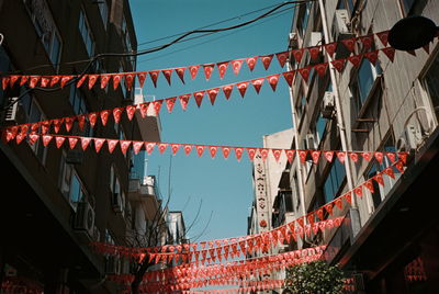 Low angle view of flags hanging against buildings in city