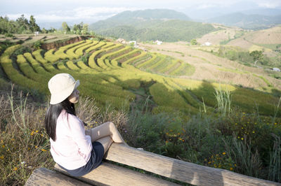 Rear view of woman sitting in farm