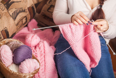 The woman knits woolen clothes. knitting needles. close-up. natural wool