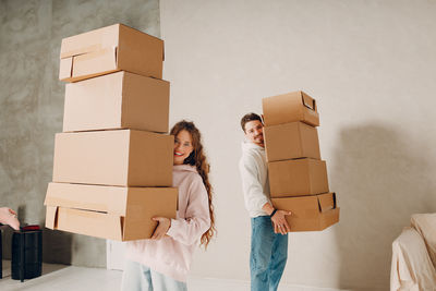 Rear view of woman sitting in cardboard box