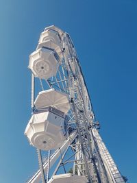 Low angle view of ferris wheel against clear blue sky