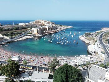 High angle view of buildings by sea against clear sky