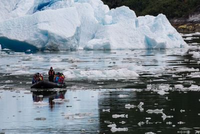 People in boat on lake during winter