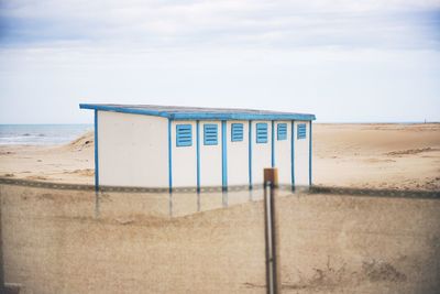 Lifeguard hut on beach against sky