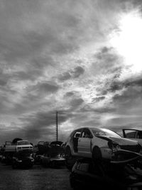 Cars on road against cloudy sky