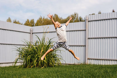 Man by plants on field against sky