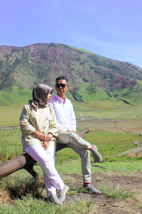 Full length of men sitting on land