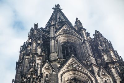 Low angle view of cologne cathedral against cloudy sky