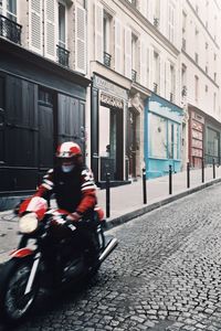 Man riding motorcycle on street in city