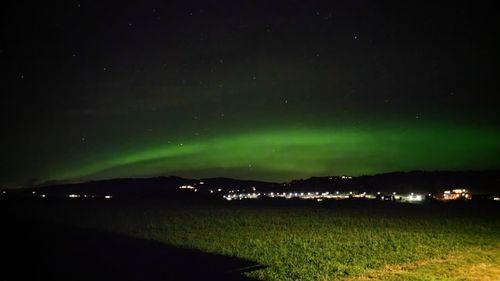 Scenic view of illuminated landscape against sky at night