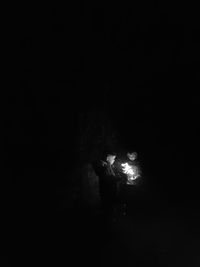 Silhouette woman in illuminated light against black background