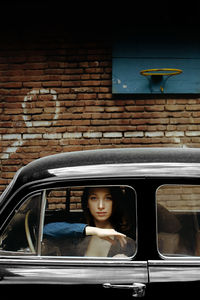 Portrait of woman sitting in car window