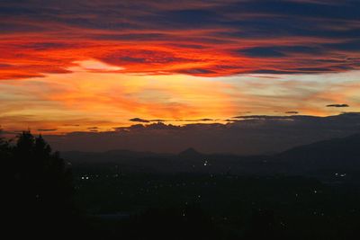 Scenic view of dramatic sky over silhouette landscape