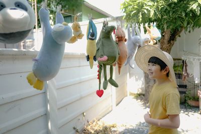 Low angle view of girl hanging on bird sculpture
