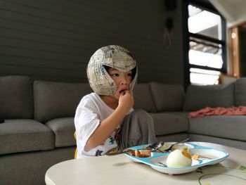 Close-up of boy eating food by table at home