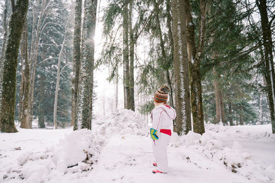 Rear view of woman standing in forest