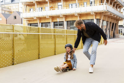 Girl on skateboard with father
